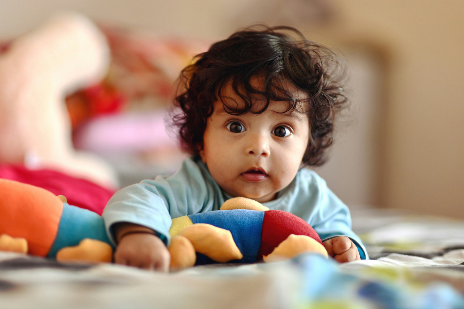 baby looking directly at camera with toy in front