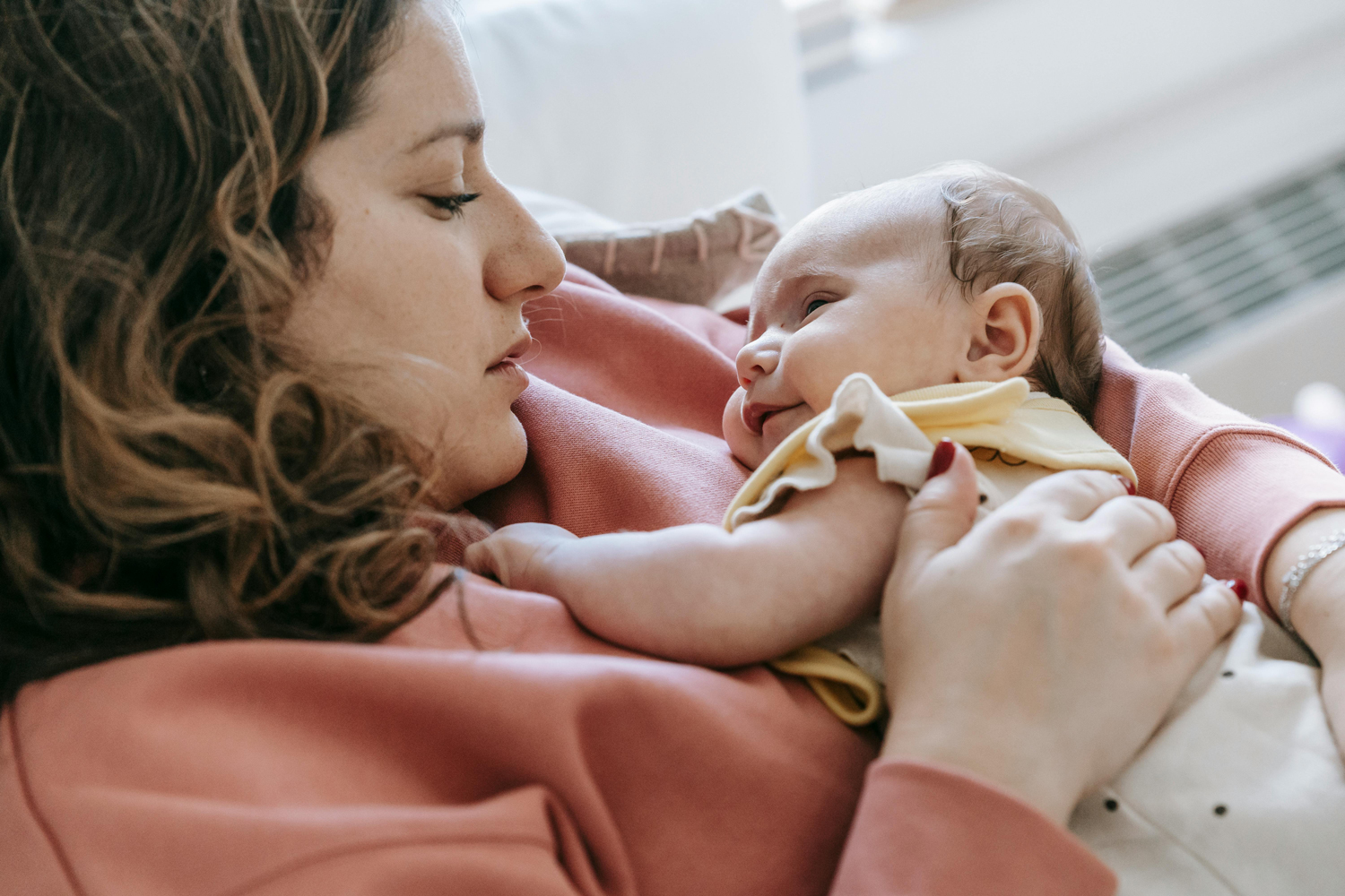 Mum sat at home holding baby