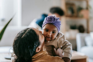 mum holding baby and kissing on the cheek