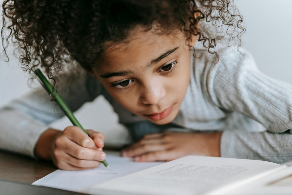 Primary school child working and desk with pen and pad
