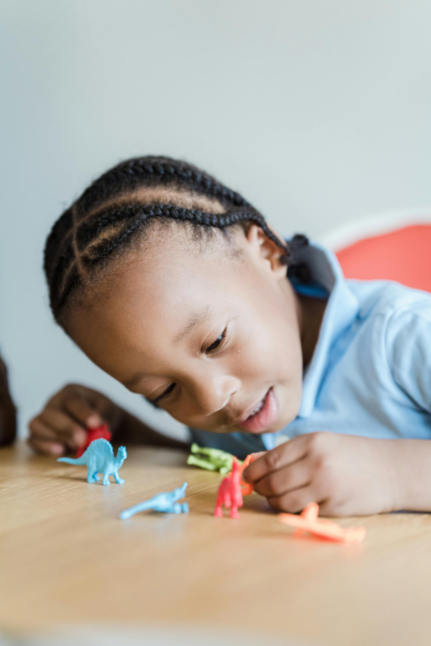 young primary school child playing with dinosaur figurines