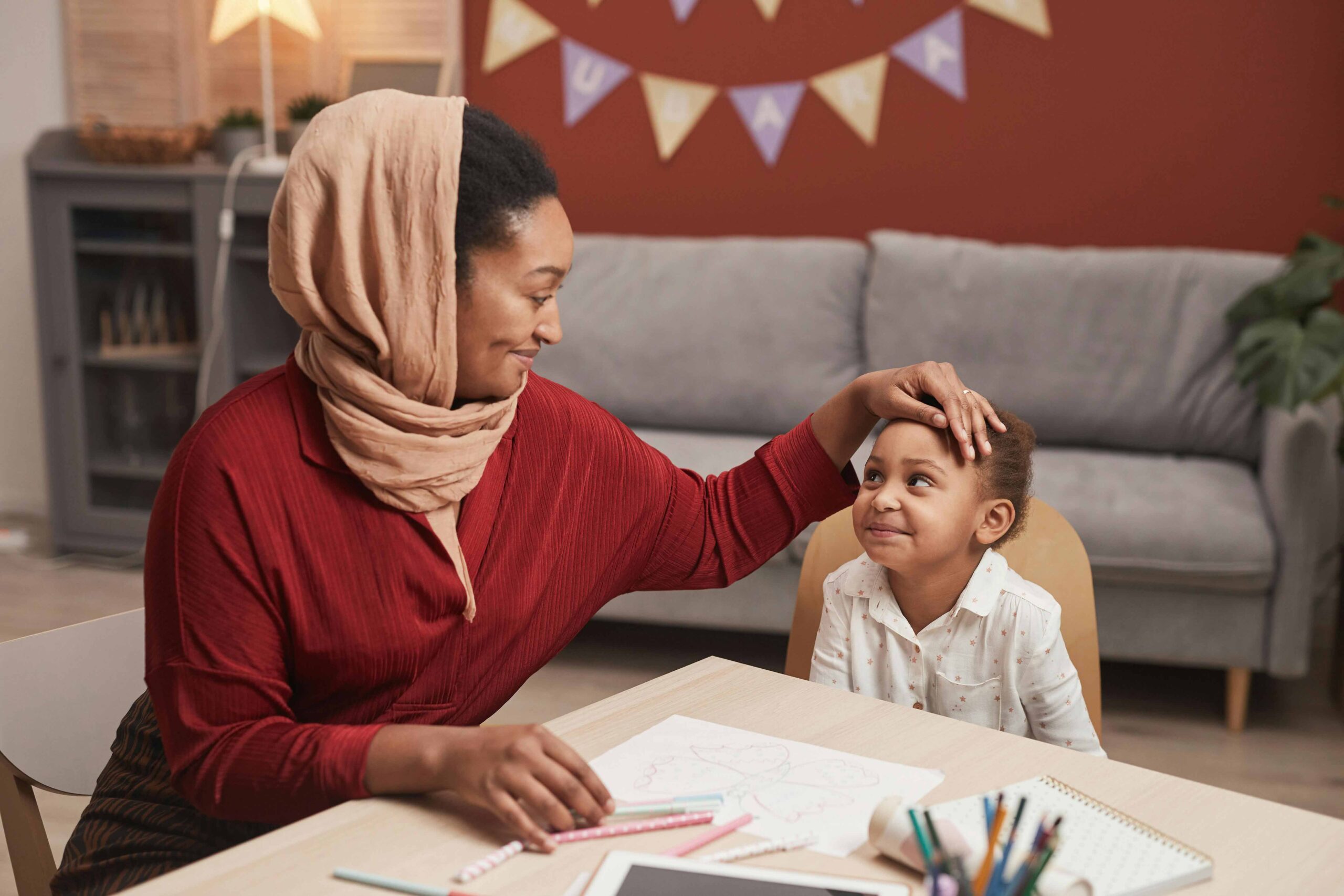 mum and girl smiling sitting at table together