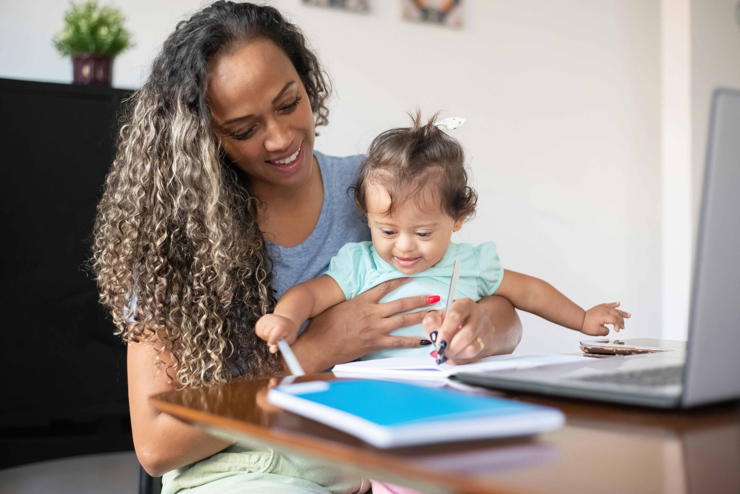 mum working and holding child smiling