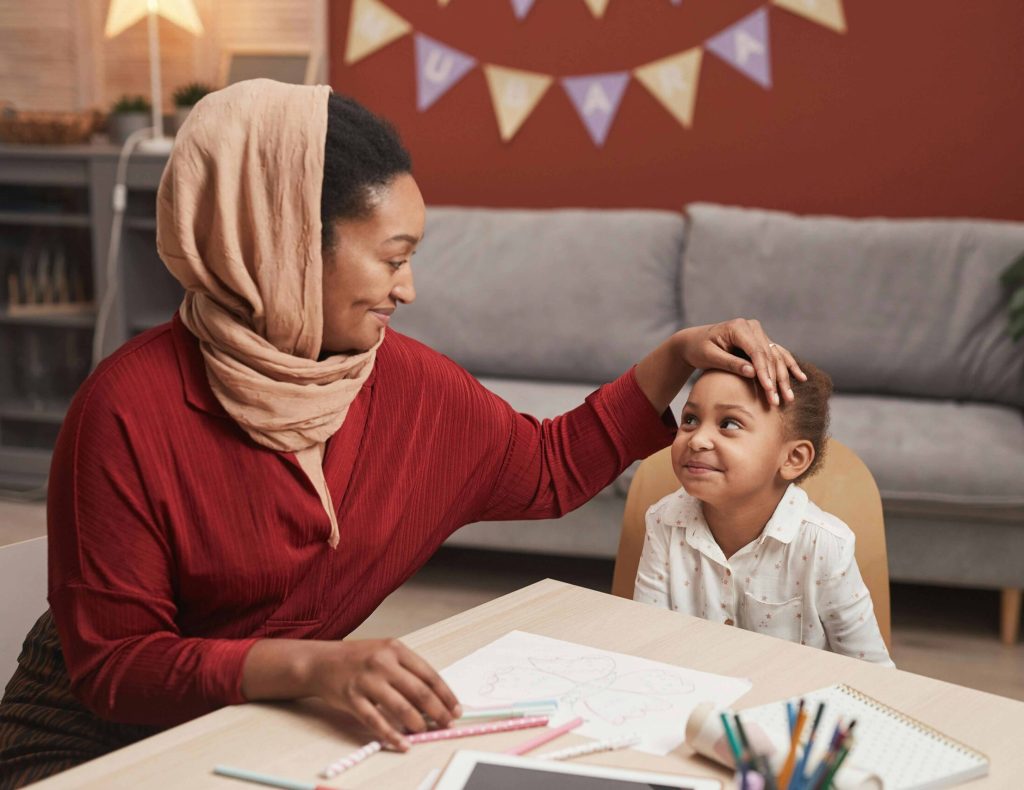 mum and girl smiling sitting at table together