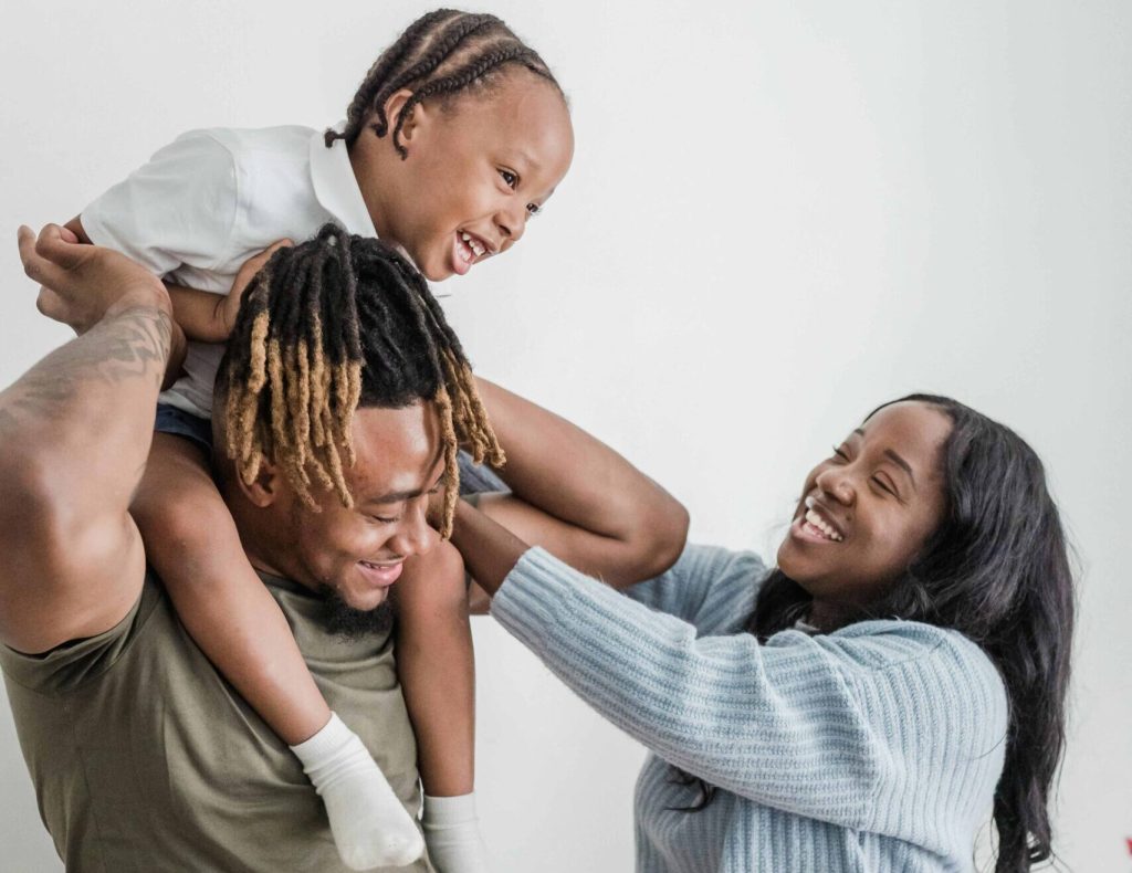 mum tickling boy on dads shoulders
